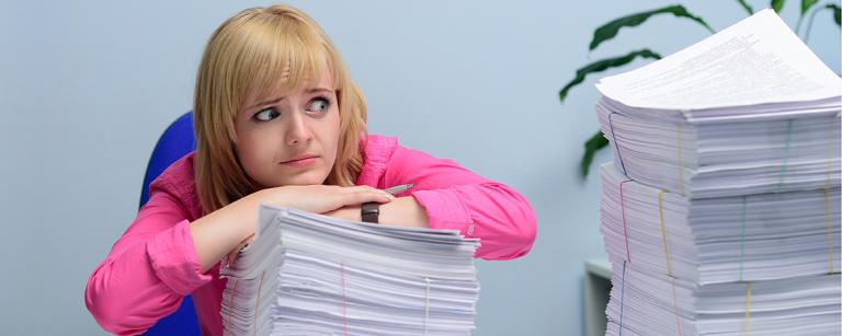 Recruitment panellist looking overwhelmed at huge stack of applications.