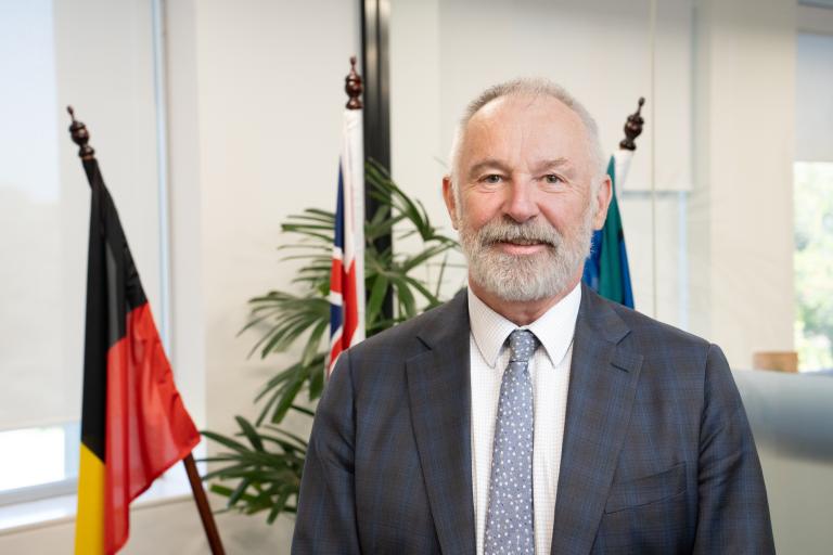 A photograph of Dr Gordon de Brouwer, Australian Public Service Commissioner. He is facing the camera and smiling.