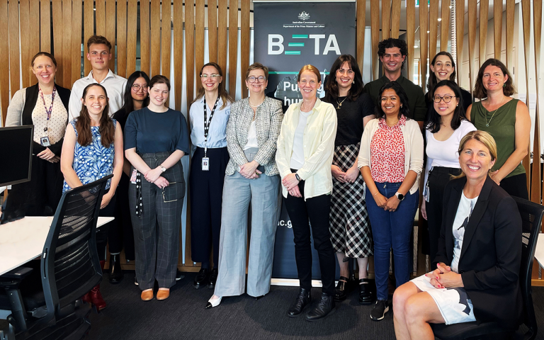 A group photograph of smiling staff members from the Behavioural Economics Team of the Australian Government, based at the Department of Prime Minister and Cabinet. 