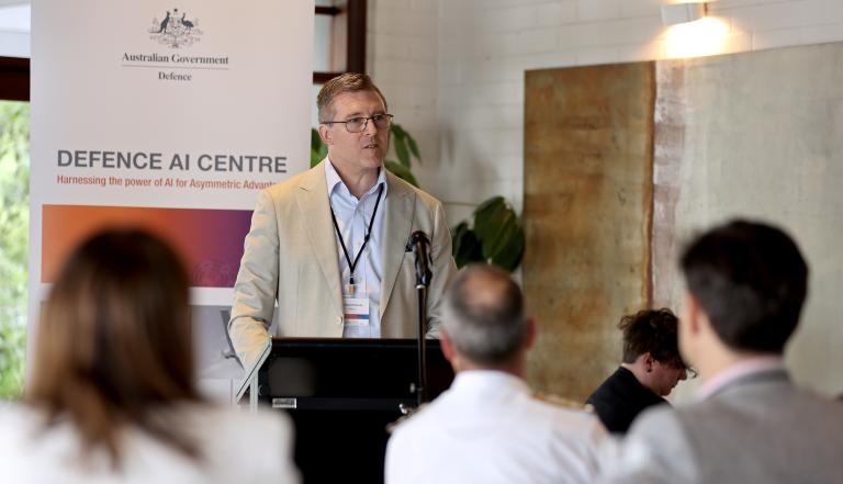 A photograph of Dr Paul Robards AM, Chief Data Integration Officer, giving a speech to the audience at the Defence AI Centre launch event. 