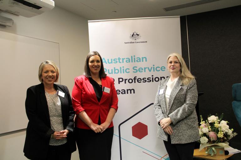 Three HR professionals in Perth smile in from of a HR Professional Stream banner