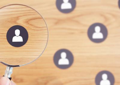 Magnify glass looking at icon of person