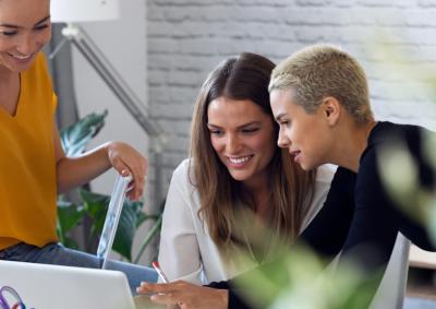 Stock photo of women looking at a laptop and smiling